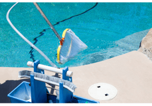 Image of a pool being skimmed and cleaned free of leaves and debris and vaccuumed.