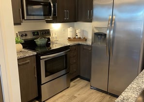 a kitchen with a stainless steel refrigerator and a refrigerator