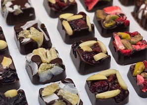 Artisan dark chocolate squares topped with dried fruits and nuts, handcrafted for elegant gifting and