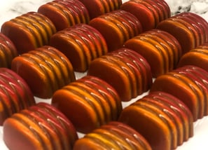 Handcrafted chocolates with cocoa butter decoration in vibrant colors luxury shine chocolates from ChocosCookiesCakes