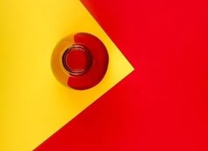 Pelota roja y amarilla en una esquina con fondo amarillo y rojo