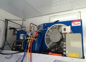 a blue and white air conditioner with a fan and a fan