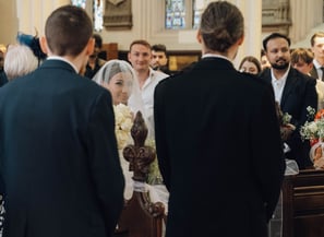 a bride and groom walking down the aisle of a church