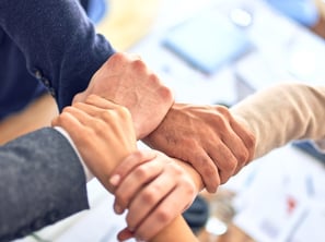 4 people holds wrists forming connection