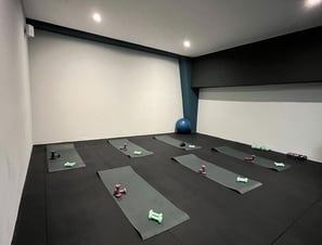 Sala fitness della palestra Move 2 Grow a Milano con tappetini, manubri e attrezzature per allenamenti di gruppo.