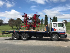 transporting new hay rake to farmer from dealer shop