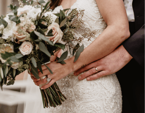 a cis couple on their wedding day, featuring the colour schemr through the brides bouquet of flowers