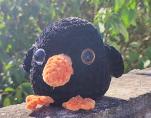 a stuffed penguin sitting on a ledge