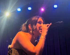 LuxeBand singer performing on stage at a corporate event