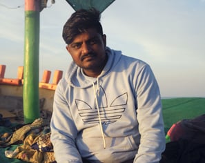a man sitting on a blanket in a tent