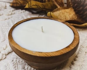 a candle with a candle in a wooden bowl