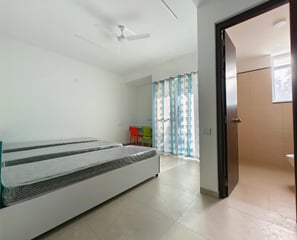 Comfortable double bed in a hotel room with a window overlooking the city