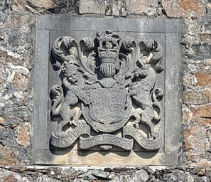 a stone wall with a coat of arms and a shield on it