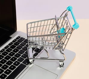 a shopping cartonce with a shopping cartonce in front of a laptop