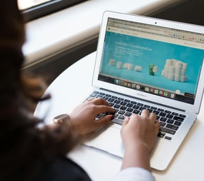 Une femme assise avec son ordinateur, sur le site internet d'une entreprise.