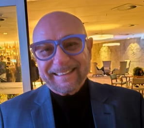 a man in a suit and glasses smiling