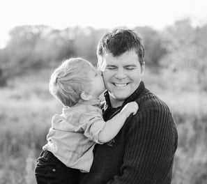 little boy kissing father on the cheek. Black and white image.