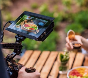 a person holding a camera and taking a video of a person holding a drink