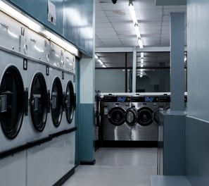 a row of washing machines in a laundry room