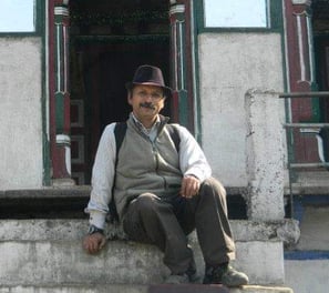 a man sitting on a ledge in front of a building