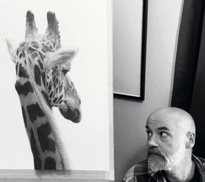 A photo of Will Arden with a drawing of a giraffe