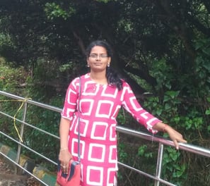 a woman in a pink dress standing on a bridge
