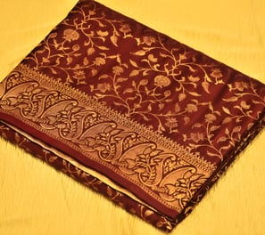 Luxurious maroon Banarasi silk saree adorned with intricate gold zari work, ideal for grand occasion