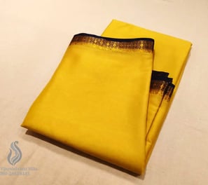 Bright yellow silk saree with elegant gold and black border, perfect for festive occasions.