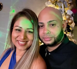 a man and woman standing next to a christmas tree