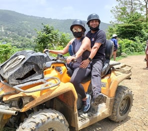 a man and woman riding on a quad - bike