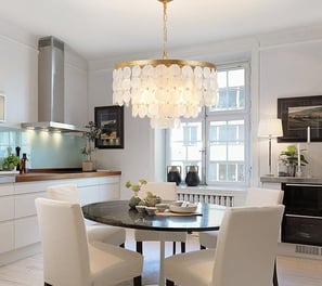 a dining room with a table and chairs under a Capiz shell chandelier