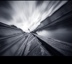 a person standing on a rock in the middle of a mountain