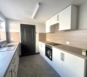 a kitchen with a stove top oven and a sink