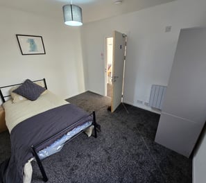 a bedroom with a bed and a lamp