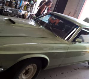a man in a green shirt is standing next to a car