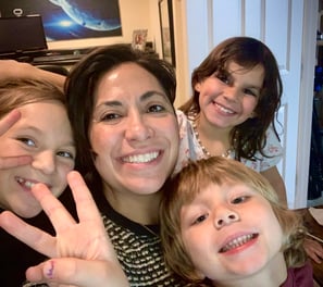 a woman with two children and a baby in a living room