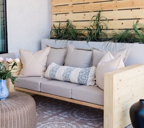 a couch with pillows and pillows on a patio