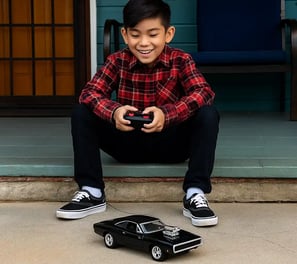 niño jugando con un carro Dodge a control remoto