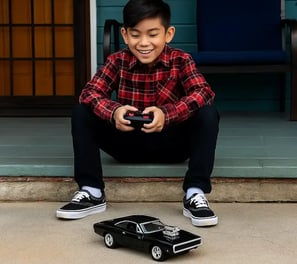 niño jugando con un carro Dodge a control remoto