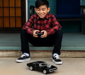 niño jugando con un carro Dodge a control remoto