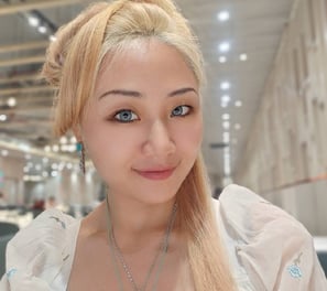 a woman with blonde hair and a necklace with a pendant