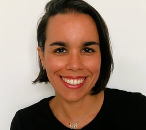 Mujer de pelo corto morena y sonriente que lleva una camisa negra