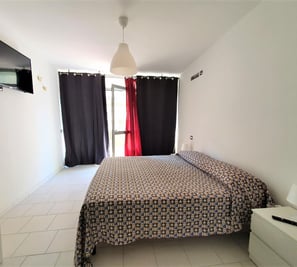 a bed room with a bed and a television