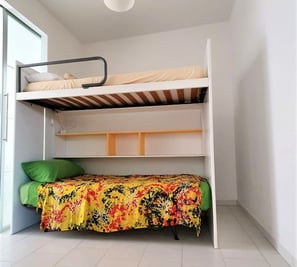 a bunk bed with a colorful bed and a yellow blanket