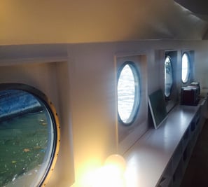 Patrijspoorten in de woonkamer van een woonboot