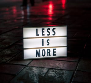 a sign that says less is more at night on a wet street