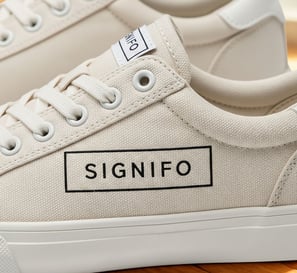 Desain sepatu sneakers kanvas mocha SIGNIFO dengan logo di bagian samping.