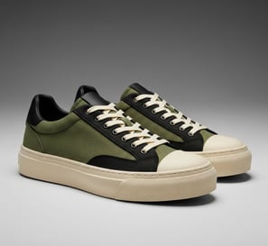 Sepatu kets pria dari kanvas hijau army dengan aksen hitam dan sol putih.