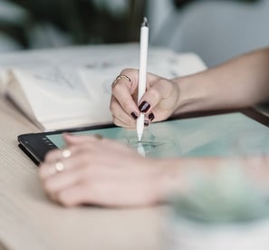 Personne dessinant sur sa tablette avec un stylet