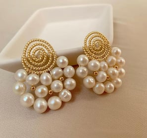 a pair of earrings with pearls and gold